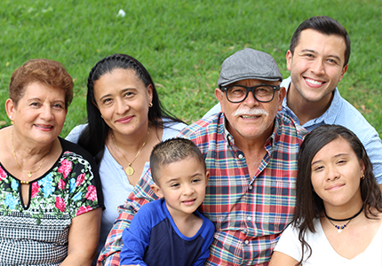 A multi-generational Hispanic family smiles for a photo.